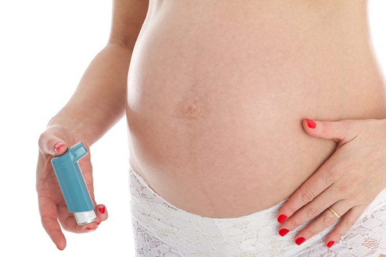 Unrecognizable pregnant woman with asthma inhaler